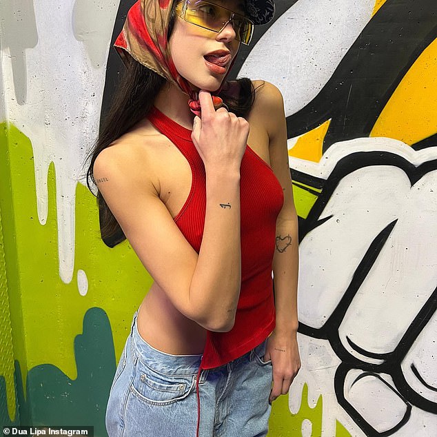 Dua Lipa, alluring with her loose waves, underneath yellow-tinted glasses
